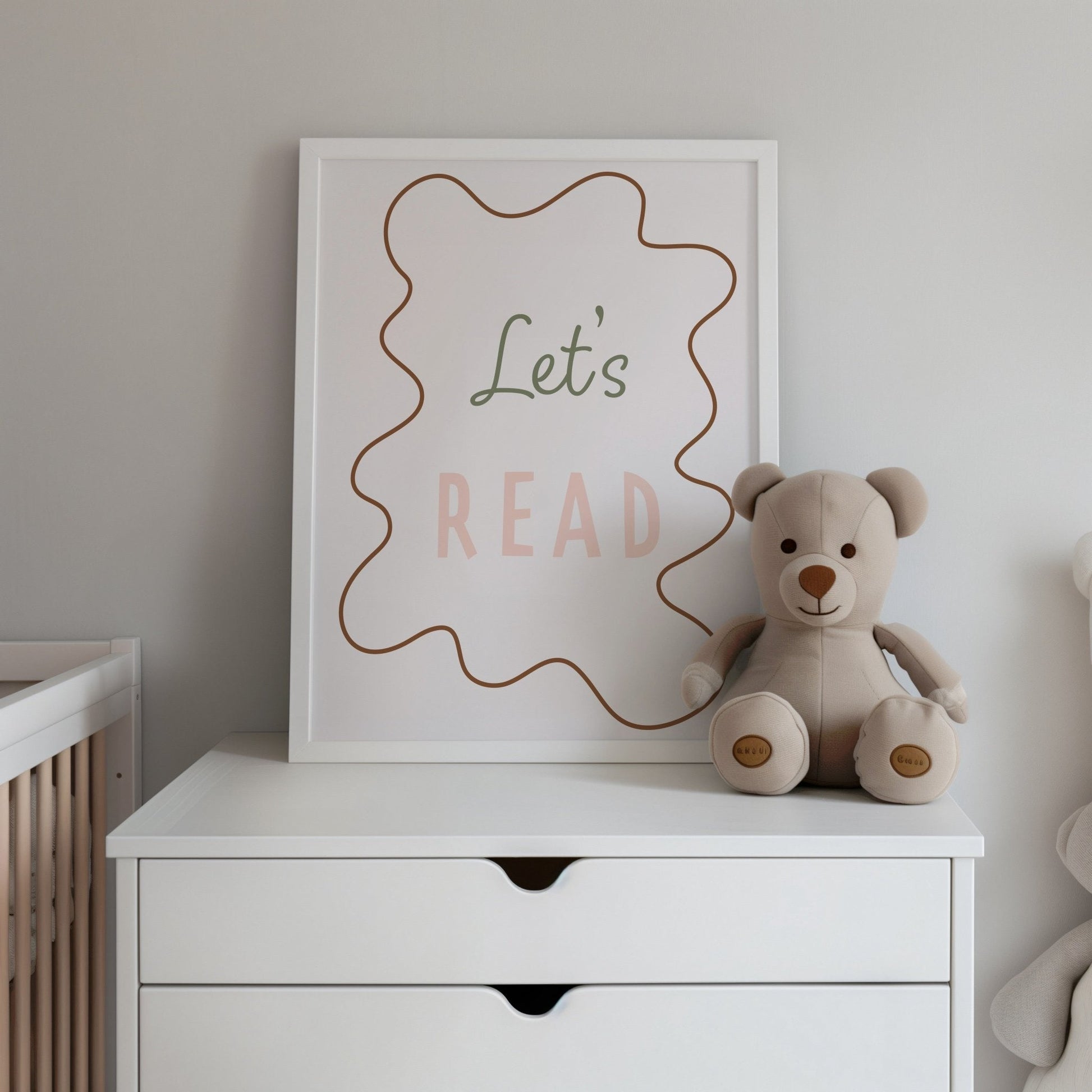 Nursery scene with a teddy bear and 'Let's Read' sign on a white dresser.