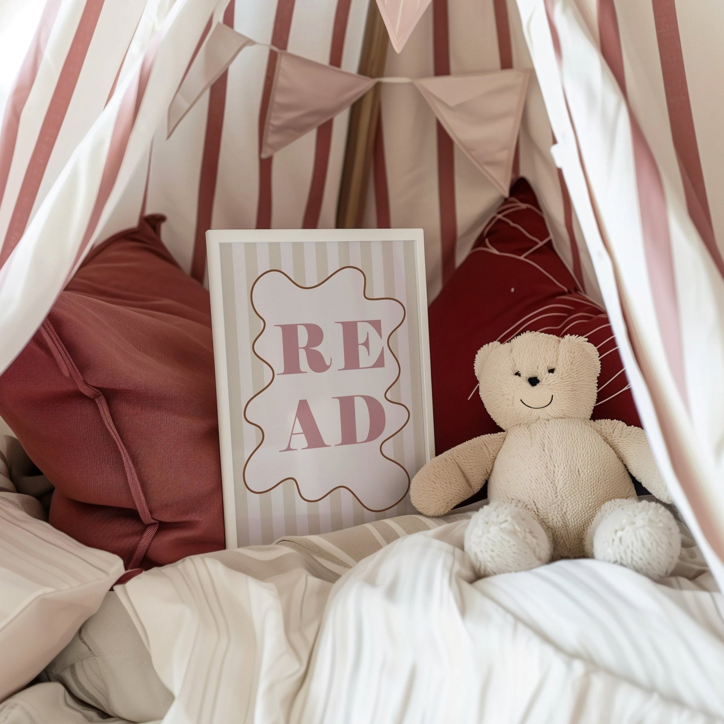 Children's reading nook with teddy bear, pillows, and 'READ' sign.