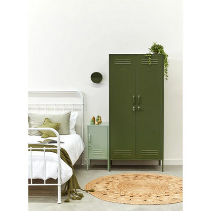 Green metal locker in a bedroom with a bed and nightstand.