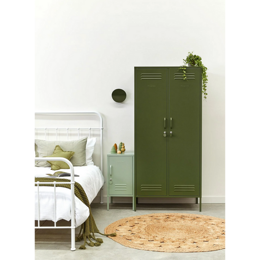Green metal locker in a bedroom with a bed and nightstand.