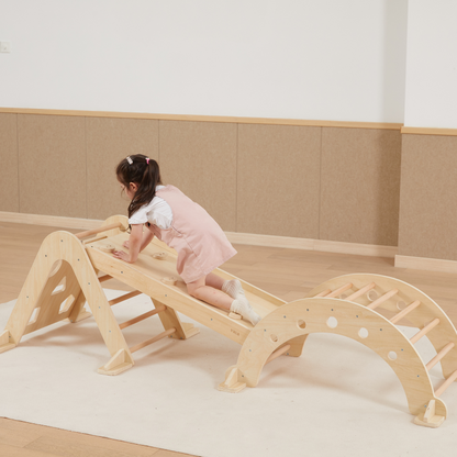 Child playing on a wooden climbing toy in a room with beige walls and flooring.