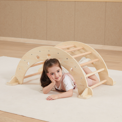 Child playing with a wooden climbing toy on a beige floor.