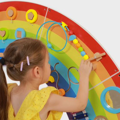 Child playing with a colorful educational toy shaped like a rainbow.