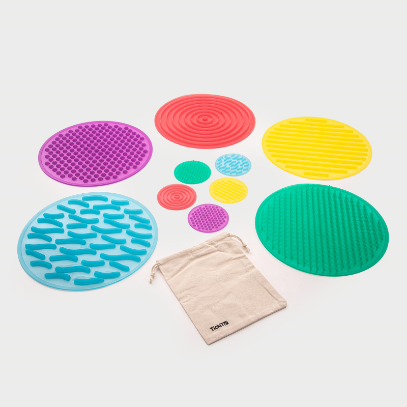 Colorful textured mats with a drawstring bag on a white background
