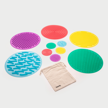 Colorful textured mats with a drawstring bag on a white background