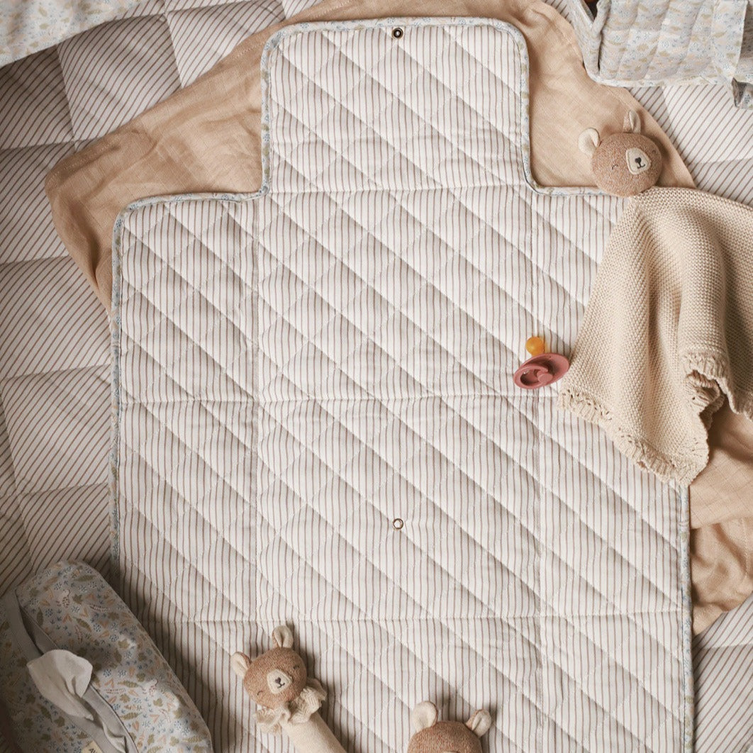Textured quilt on a bed with toys and blankets