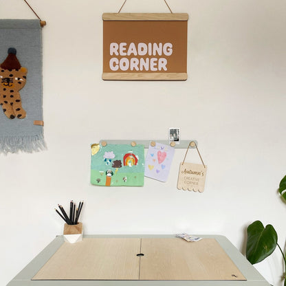 Children's play area with a table, wall decorations, and a 'Reading Corner' sign.