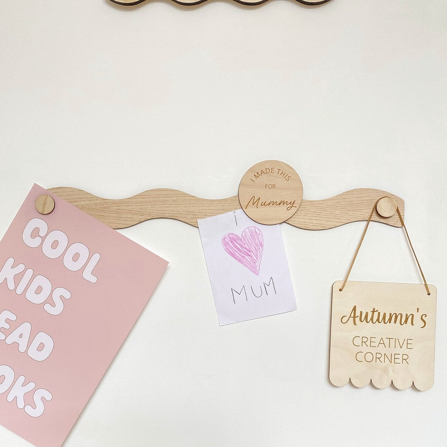 Wooden peg board with hanging signs on a white background