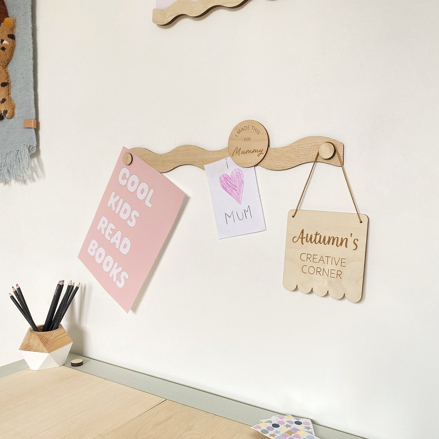 Children's desk setup with motivational signs and a decorative wall hook.