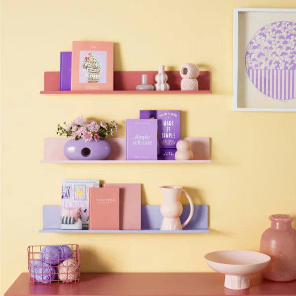 Shelves with decorative items against a yellow wall