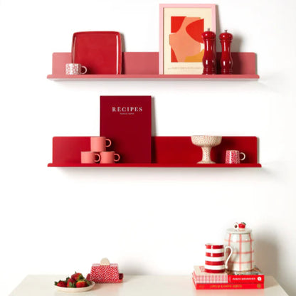 Red shelves with kitchen items against a white wall