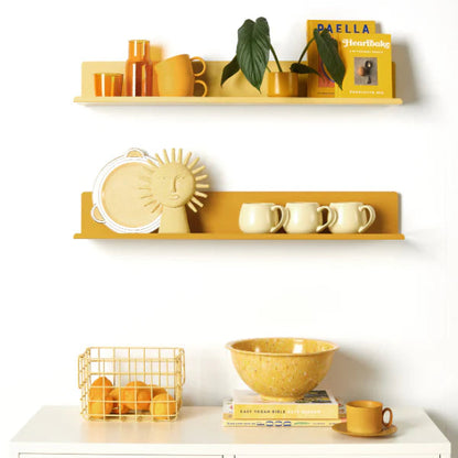 Yellow shelves with decorative items against a white wall