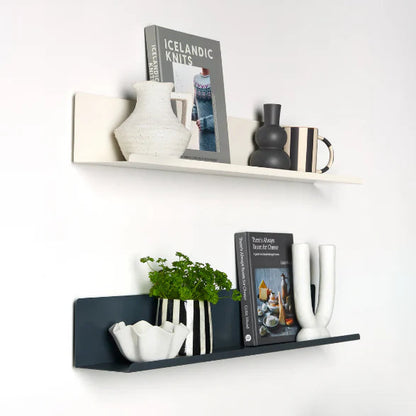 Decorative shelves with books, vases, and plants against a white wall.