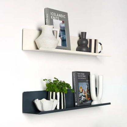 Decorative shelves with books, vases, and plants against a white wall