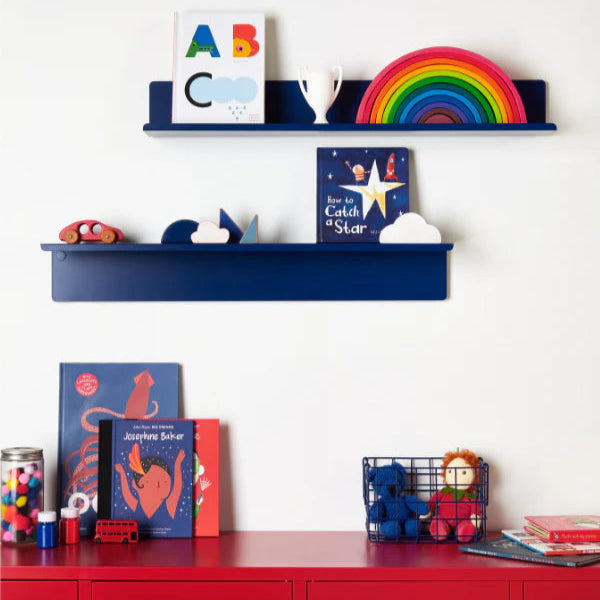 Children's room with blue shelves and red locker, featuring books and toys.