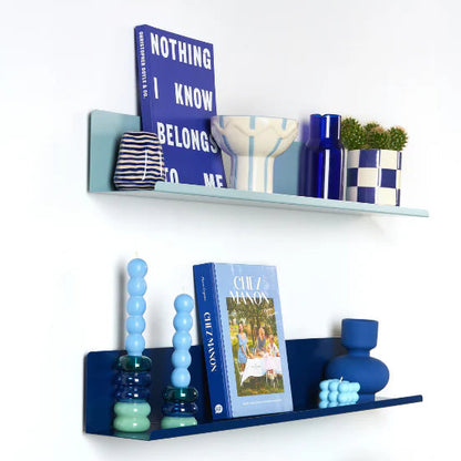 Decorative shelves with books, vases, and a lamp on a white wall.