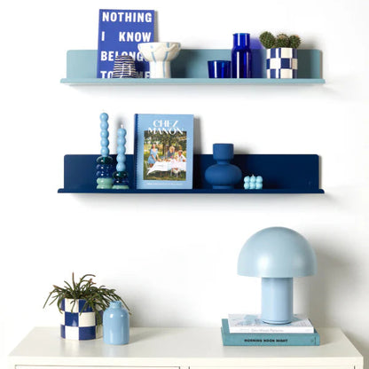 Decorative shelves with blue and white items against a white wall
