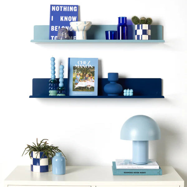 Decorative shelves with blue and white items against a white wall
