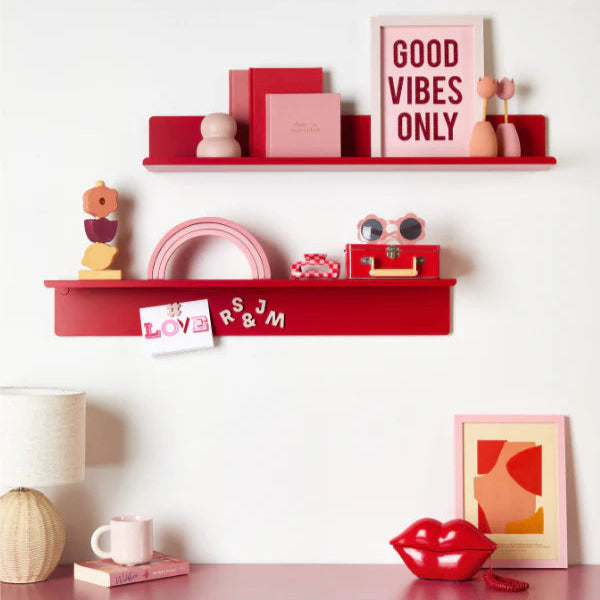 Pink shelves with decorative items against a white wall