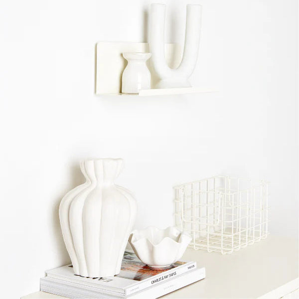 White shelf on a white wall with white decorations