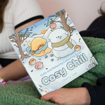 Coloring book titled 'Cosy Chill' held by a person wearing a green sweater.