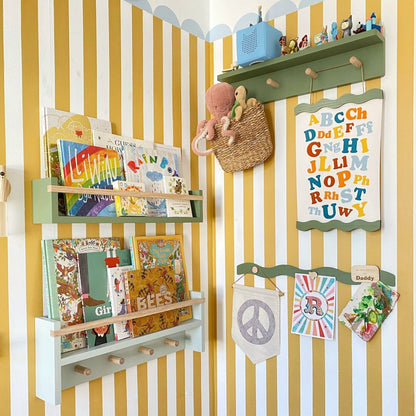 Children's room with striped walls, shelves with books and toys, and colorful alphabet chart.