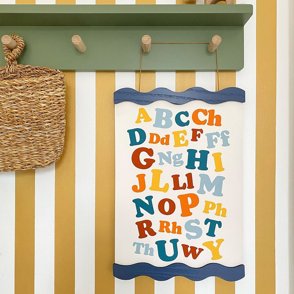 Children's alphabet chart on a wall with striped pattern