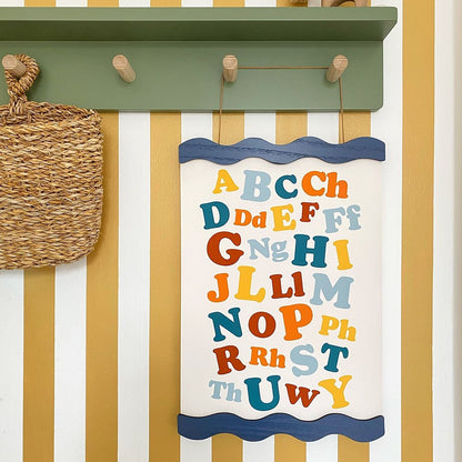 Children's alphabet chart on a wall with striped pattern